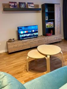 sala de estar con 2 mesas y TV en Blue Mountain Residence, en Brasov