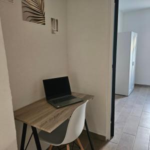 - un ordinateur portable installé sur une table en bois dans l'établissement Emplacement Idéal : Appartement 2 Chambres en Plein Cœur d'Orange, à Orange