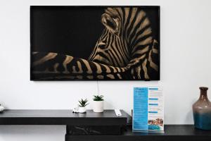 a painting of a zebra sitting on a wall at Grace at Mosman Apartments in Sydney