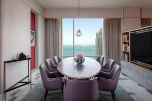 Andaz Doha, A Concept by Hyatt في الدوحة: غرفة مع طاولة وكراسي ونافذة كبيرة