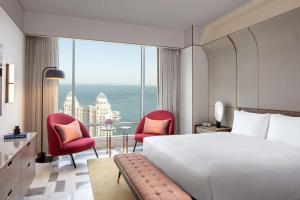 ドーハにあるAndaz Doha, A Concept by Hyattのベッドと大きな窓が備わるホテルルームです。