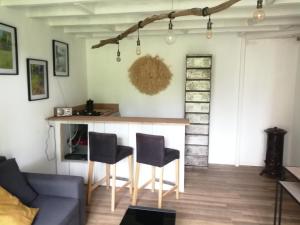 een woonkamer met een bar en 2 stoelen bij La Canardière in Pendé