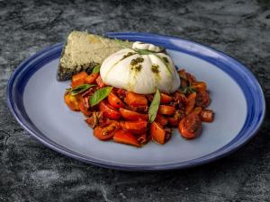 un plato de comida con un huevo encima de zanahorias en Mercure Nairobi Upper Hill en Nairobi