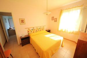 a bedroom with a yellow bed and a window at Villa Margherita Bilocale - Taunus Vacanze in Numana