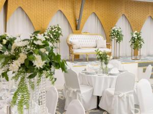 a room with white tables and chairs and a couch at Mercure Alger Palais Des Congres in Alger +66 photos