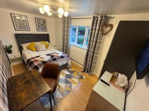 Schlafzimmer mit einem Bett, einem Tisch und einem Schreibtisch in der Unterkunft Brick lodge house in Castle Donington