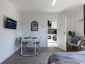 a bedroom with a table and chairs and a kitchen at # VAZ Apartments E01 Küche, TV, Netflix, ca 15 Min Messe u HBf in Essen