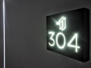 a neon clock on the side of a wall at Number 11 St Julian's Malta - Handwritten Collection in St. Julianʼs