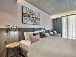 a living room with a bed and a couch at Number 11 St Julian's Malta - Handwritten Collection in St. Julianʼs