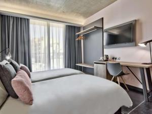 a hotel room with a large bed and a desk at Number 11 St Julian's Malta - Handwritten Collection in St. Julianʼs