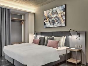 a bedroom with a large white bed with pink pillows at Number 11 St Julian's Malta - Handwritten Collection in St. Julianʼs