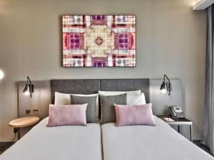 a bedroom with a large bed with pink pillows at Number 11 St Julian's Malta - Handwritten Collection in St. Julianʼs