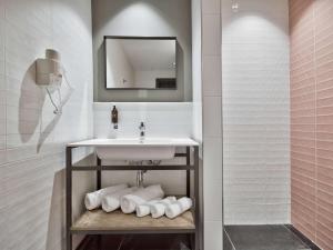 a bathroom with a sink and a shelf with towels at Number 11 St Julian's Malta - Handwritten Collection in St. Julianʼs