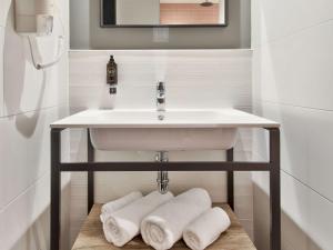 a bathroom with a sink with towels under it at Number 11 St Julian's Malta - Handwritten Collection in St. Julianʼs
