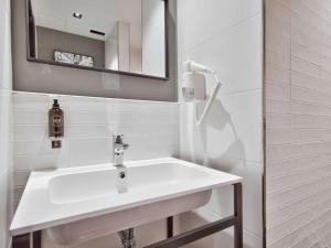 a white bathroom with a sink and a mirror at Number 11 St Julian's Malta - Handwritten Collection in St. Julianʼs