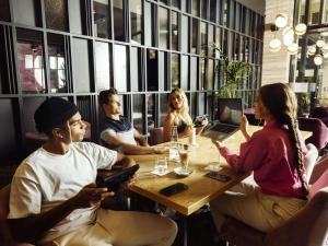 a group of people sitting around a table in a restaurant at Number 11 St Julian's Malta - Handwritten Collection in St. Julianʼs