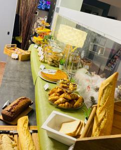 a long table with bread and pastries on it at Hotel & Spa Gil de France Cap d'Agde in Cap d'Agde