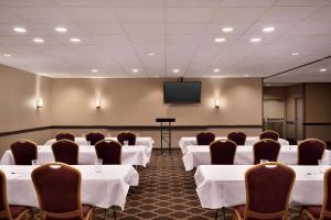 a conference room with white tables and chairs and a screen at Baymont by Wyndham Culpeper in Culpeper