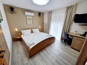 ein Schlafzimmer mit einem großen Bett und einem Schreibtisch. in der Unterkunft Hotel Rheintal in Kappel-Grafenhausen