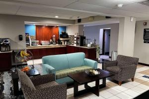 a waiting room with a couch and chairs and a table at Baymont By Wyndham Monroe Ohio in Monroe