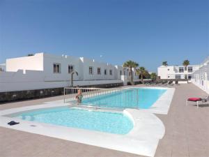 una piscina con una persona a su lado en Gracioseros 211, en Puerto del Carmen