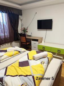 2 Betten in einem Zimmer mit einem Schreibtisch und einem TV in der Unterkunft Zimmer in Ein Haus mit Waschmaschine in Mönchengladbach