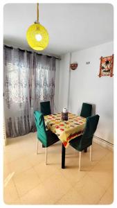 a dining room table with four chairs and a yellow light at Cosy Duplex" Sidi Bou Said " in Sidi Bou Saïd