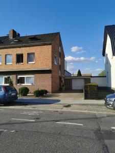 een bakstenen gebouw met een parkeerplaats ervoor bij Zimmer in Ein Haus mit Waschmaschine in Mönchengladbach +17 foto's