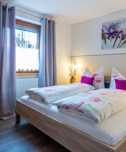 a bedroom with a large bed with pink pillows at Haus Sonnengarten-Lienz in Lienz