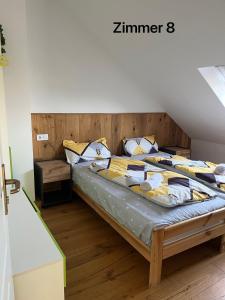 um quarto com uma cama e uma cabeceira em madeira em Zimmer in Ein Haus mit Waschmaschine em Mönchengladbach