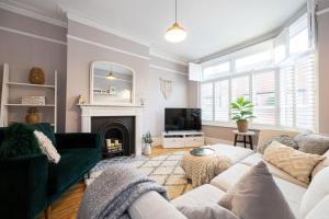 a living room with a green couch and a fireplace at GuestReady - Ideal Stay in Chorlton in Manchester