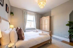 a bedroom with a large white bed with a window at GuestReady - Ideal Stay in Chorlton in Manchester