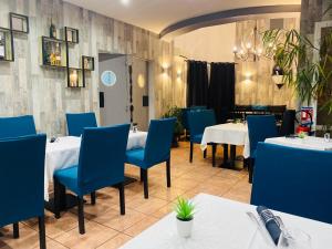 a restaurant with blue chairs and tables in a room at Hotel & Spa Gil de France Cap d'Agde in Cap d'Agde