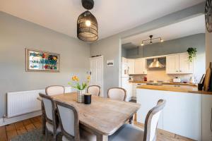 a kitchen and dining room with a wooden table and chairs at GuestReady - Ideal Stay in Chorlton in Manchester