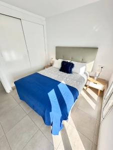 a bedroom with a blue bed in a white room at Cosmopolitan by Lovely Property in Corralejo