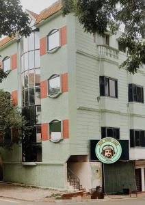 un edificio con un cartel en el costado en Funky Buddha Hostel en Mysore