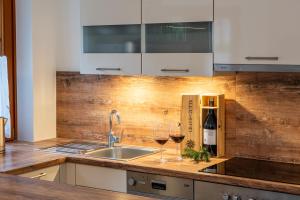 a kitchen with a sink and two glasses of wine at Haus Sonnengarten-Lienz in Lienz