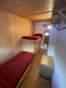 a small room with two beds and a table at Appartamento con vista sulle Pale di San Martino in San Martino di Castrozza