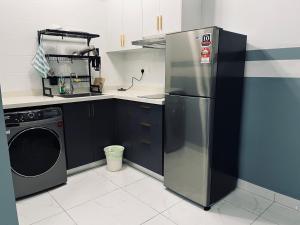 a kitchen with a refrigerator and a washing machine at Arte cheras luxury family house link MRT in Kuala Lumpur