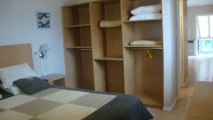 a bedroom with a bed and shelves with towels at Le Soleil Apart Hotel in Colón