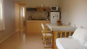 a kitchen with a table and chairs and a refrigerator at Le Soleil Apart Hotel in Colón