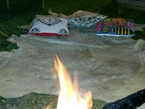 eine Feuerstelle mit zwei Kissen und eine Feuerstelle mit einem Lagerfeuer in der Unterkunft Pousada da Lua in Delfinópolis