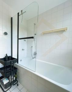 y baño con bañera y ducha acristalada. en Ruhige 3 Zimmer Wohnung gut angebunden, en Düsseldorf