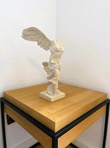 una estatua de un ángel sentado en una mesa de madera en Ruhige 3 Zimmer Wohnung gut angebunden, en Düsseldorf