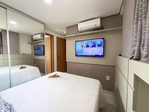 カベデロにあるApt. Prime Conforto a 100m do mar #pacifico405のベッド2台、壁掛けテレビが備わる客室です。