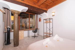a bedroom with a bed and a desk and a chair at Alh Patio Apartamentos in Granada