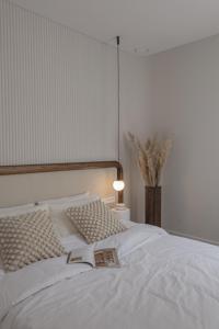 ein Schlafzimmer mit einem weißen Bett mit einem Buch darauf in der Unterkunft New and Stylish Apartment, Monaco in Beausoleil