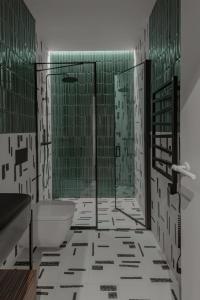 ein Badezimmer mit einer Badewanne, einem WC und grünen Fliesen in der Unterkunft New and Stylish Apartment, Monaco in Beausoleil
