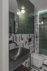 ein Badezimmer mit einem Waschbecken, einem WC und einem Spiegel in der Unterkunft New and Stylish Apartment, Monaco in Beausoleil