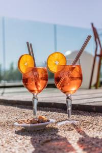 three wine glasses with orange slices on a table at Best Western Aquakub in Aix-les-Bains